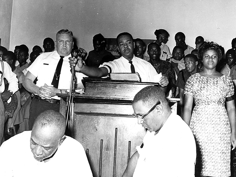 Albany police chief Laurie Pritchett (center left) with civil rights activist Slater King (center right) in Shiloh Baptist Church, where Student Nonviolent Coordinating Committee members first met.