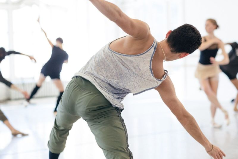 Training Program artist Aleks with limbs outstretched and back facing the camera