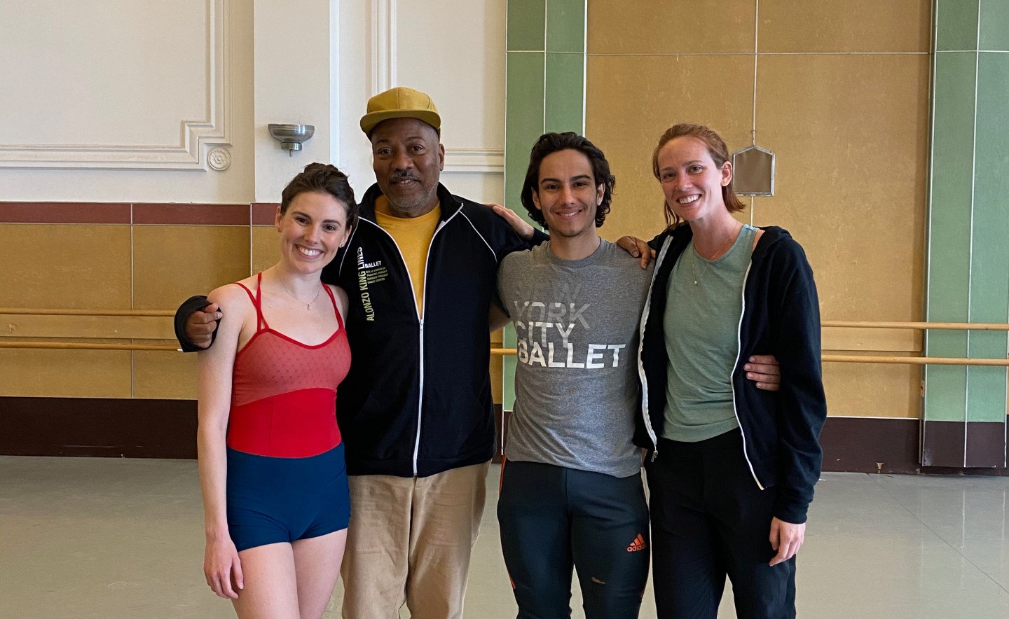 Left to Right: Tiler Peck, Alonzo King, Roman Mejia, Maddie DeVries, standing and smiling together in Studio 5 at LINES Dance Center
