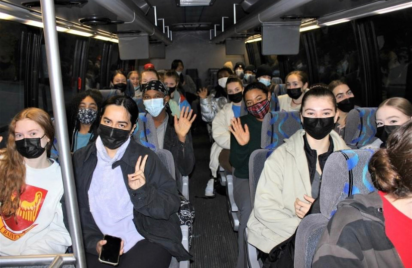 BFA at Dominican students riding the bus to the LINES Ballet studios in San Francisco, all students are wearing masks and looking to the camera, some are waving to the camera