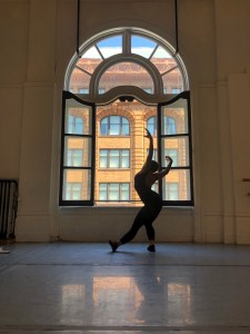 Amanda Harris dancing in front of one of the big open windows at LINES Dance Center in SF