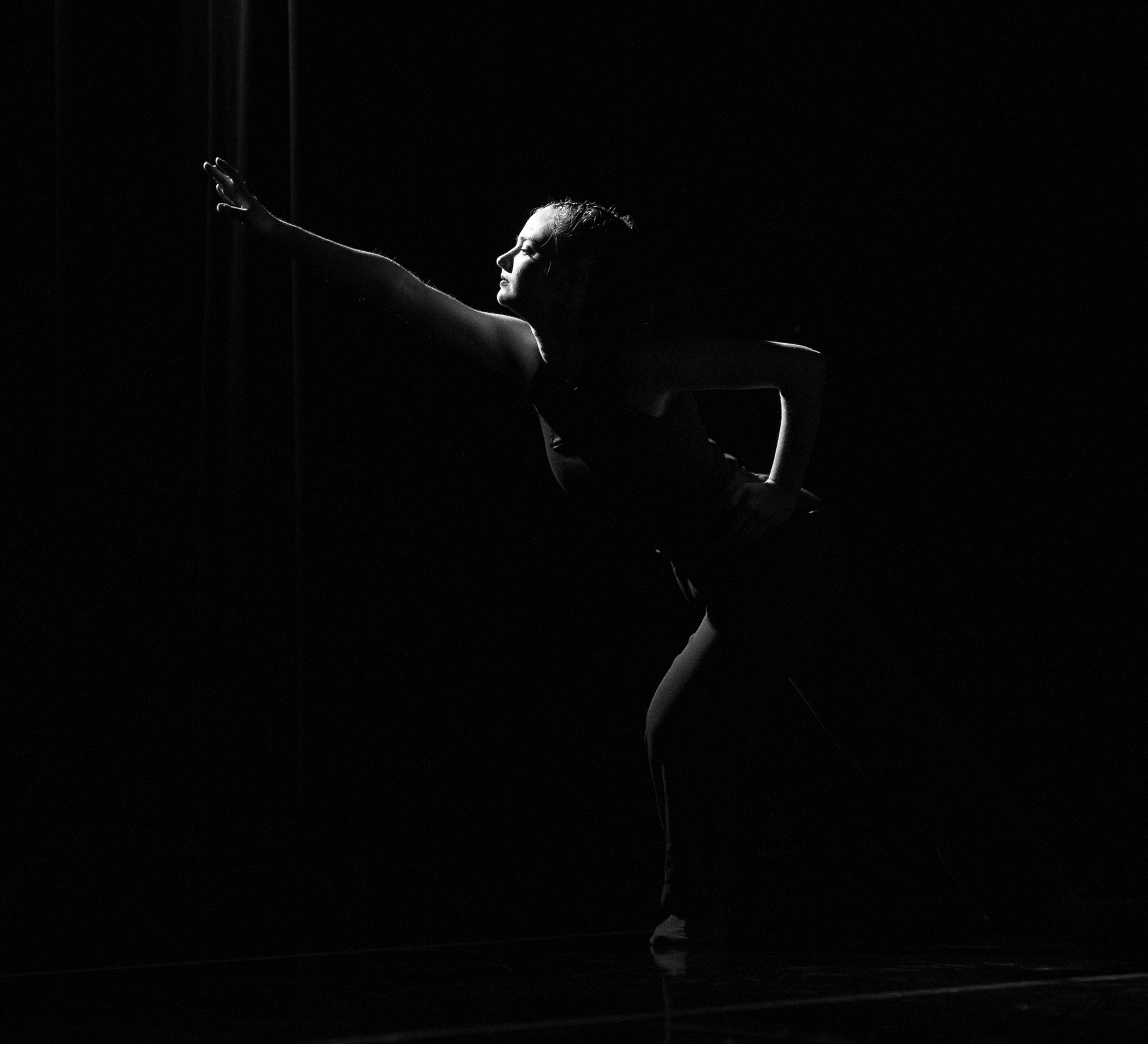 Brooke “Frank” Sinton dancing on stage at Dominican University of California (image is in black and white)