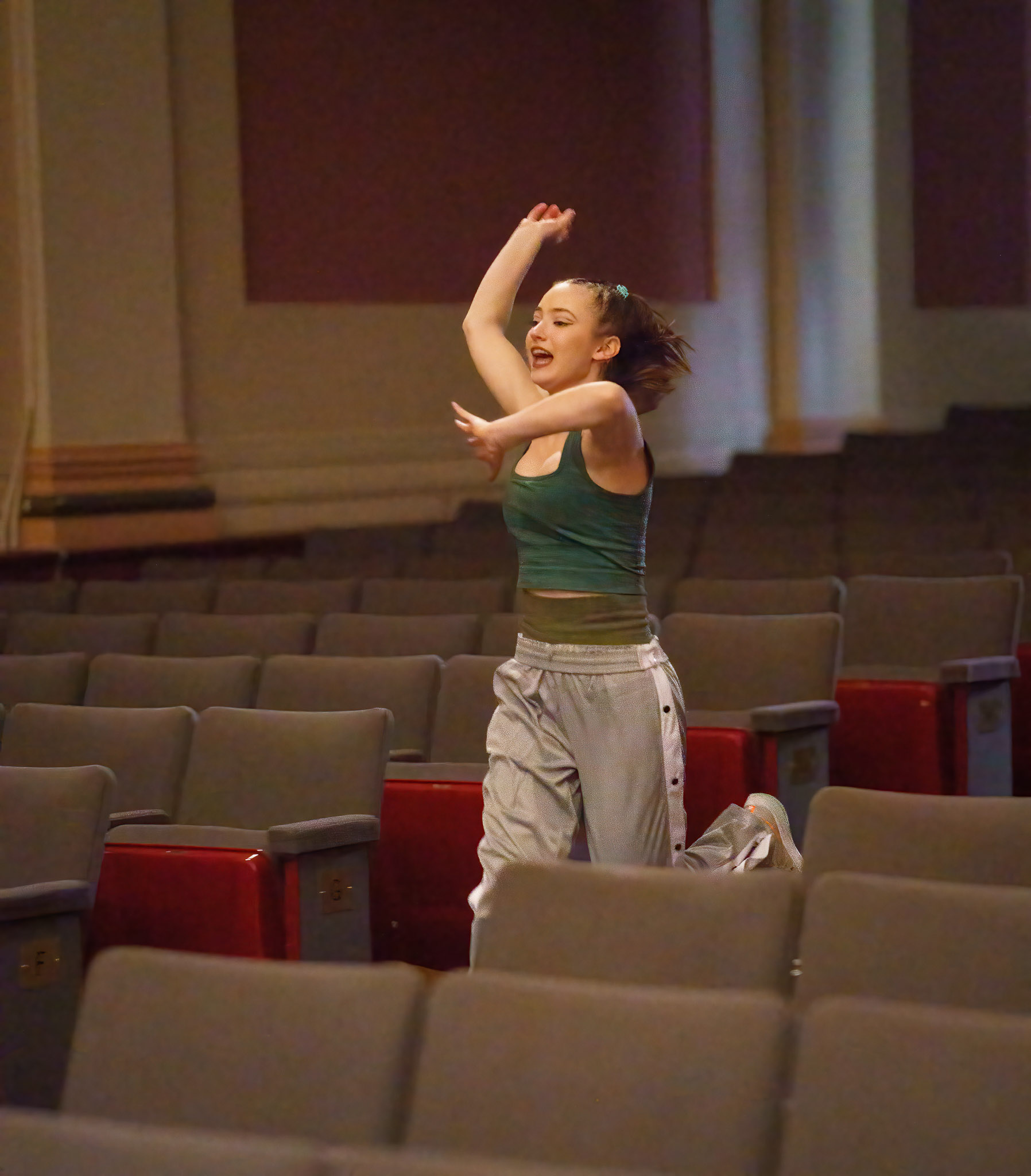 Brooke “Frank” Sinton running through the empty audience in Angelico Hall at Dominican University of California