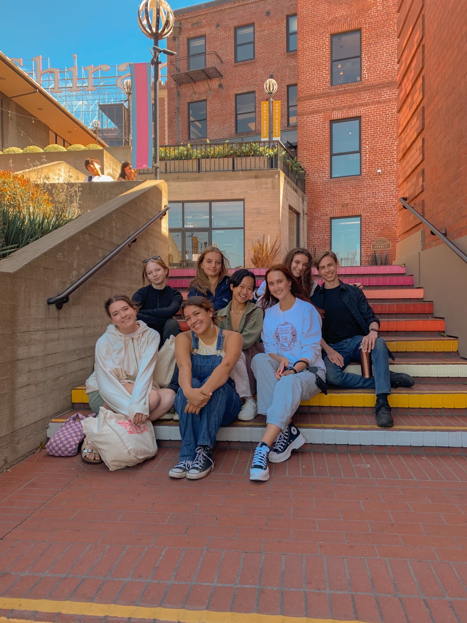 LINES Ballet Summer Program student Gabriel Warren with other Summer Program classmates outdoors in San Francisco, sitting on stairs together smiling