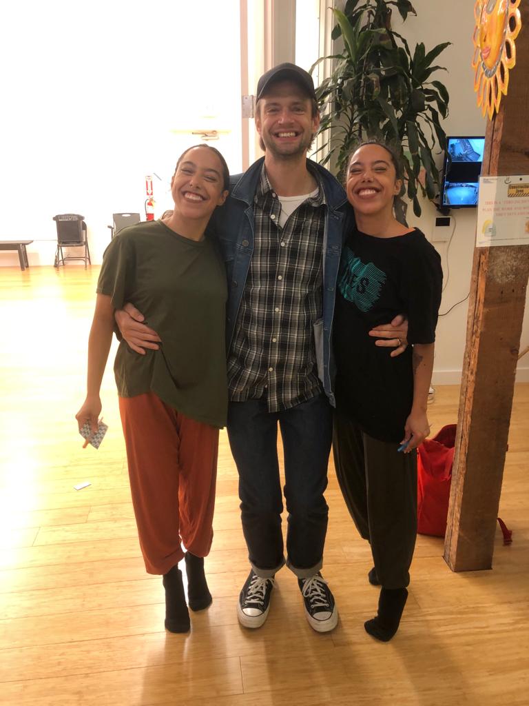 Giovana and Giulia Sales standing with Brett Conway indoors smiling together