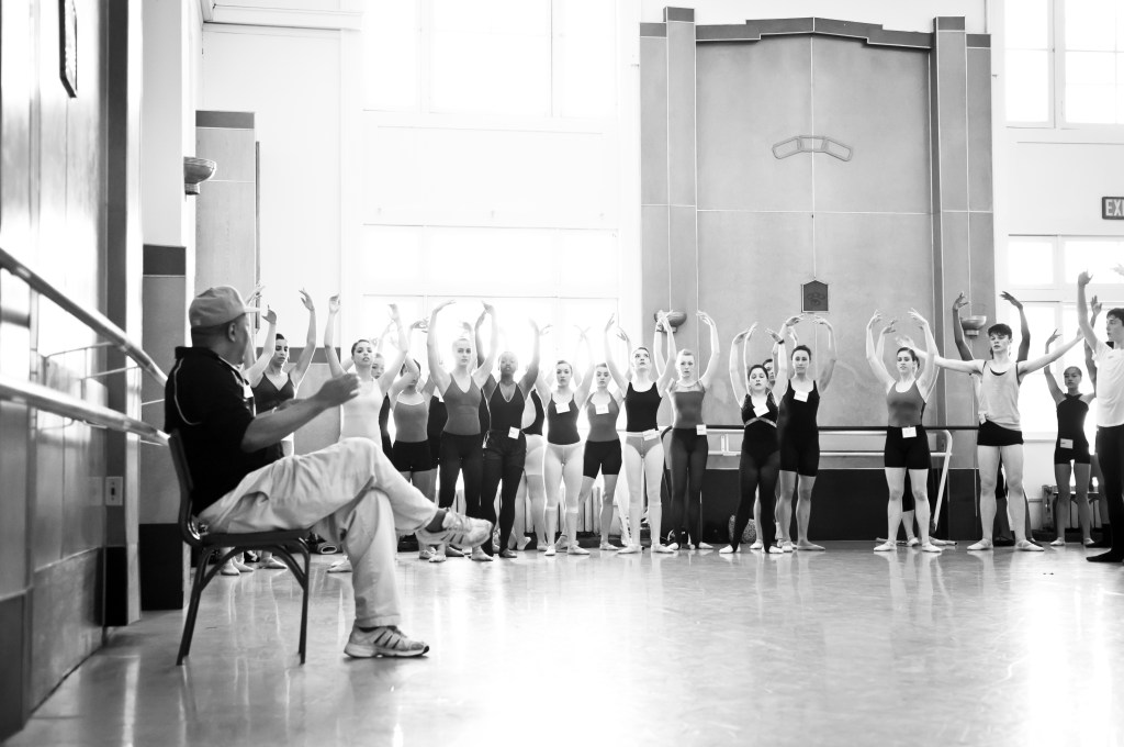 Alonzo King sits in front of Summer Program students, demonstrating a concept with arms in high fifth position at LINES Dance Center.